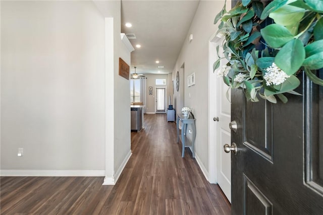 hall with dark wood-type flooring, recessed lighting, visible vents, and baseboards