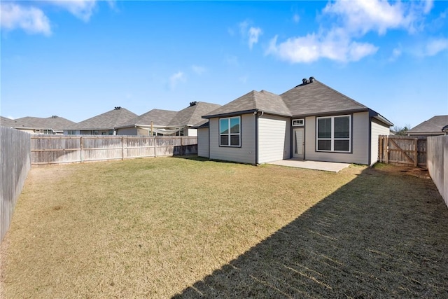 back of house featuring a fenced backyard, a yard, and a patio