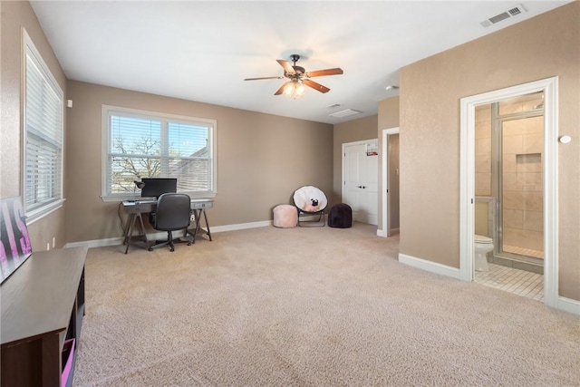 carpeted home office featuring baseboards, a ceiling fan, and visible vents