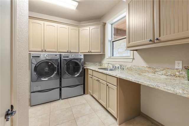washroom with cabinet space, washer and clothes dryer, light tile patterned flooring, and a sink