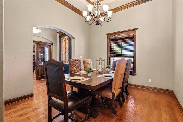 18265 Windmill Ct, College Station, TX 77845 - dining space with arched walkways, a chandelier, light wood-style flooring, and crown molding