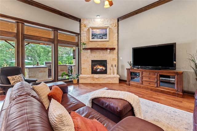 18265 Windmill Ct, College Station, TX 77845 - living area featuring ornamental molding, a stone fireplace, wood finished floors, and a ceiling fan
