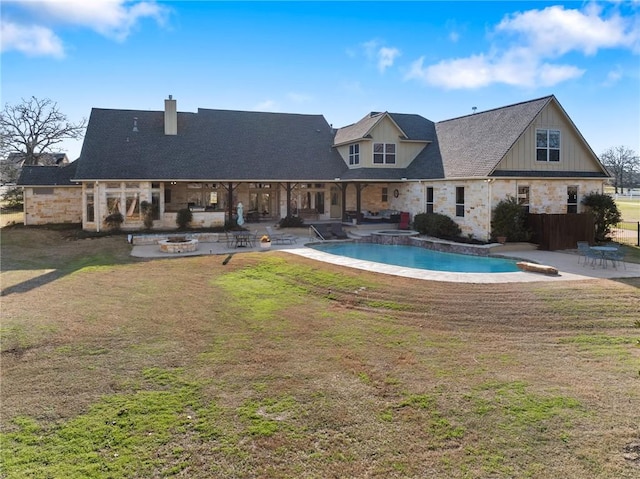 outdoor pool with a patio area, a fire pit, and a lawn