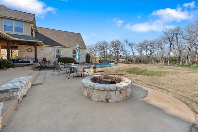 view of patio with an outdoor pool and an outdoor fire pit