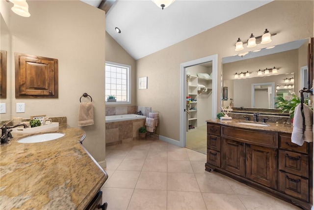 full bath featuring two vanities, vaulted ceiling, tile patterned floors, and a sink