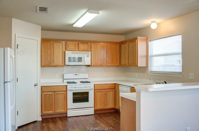 kitchen featuring kitchen peninsula, dark hardwood / wood-style flooring, white appliances, and sink