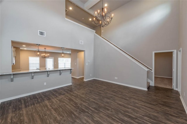 unfurnished living room with a towering ceiling and dark hardwood / wood-style floors