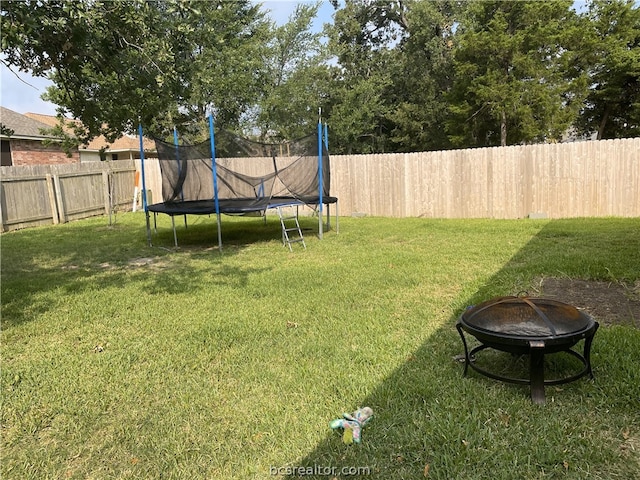 2402 Pleasant Rose Cir, Bryan, TX 77808 - fenced backyard with a trampoline and an outdoor fire pit