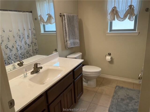 bathroom featuring toilet, plenty of natural light, vanity, and tile patterned flooring