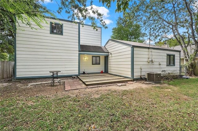 back of property with central air condition unit, roof with shingles, a yard, and fence