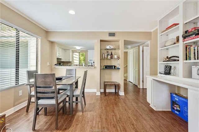 dining area with visible vents, ornamental molding, baseboards, and wood finished floors