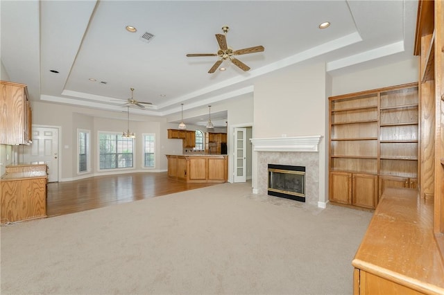 9300 Lakeside Ct, College Station, TX 77845 - unfurnished living room with a tray ceiling, a ceiling fan, light carpet, a fireplace, and recessed lighting