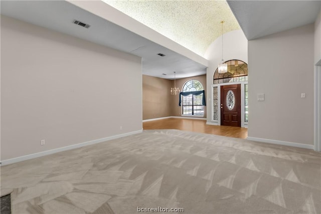 foyer featuring light carpet and an inviting chandelier