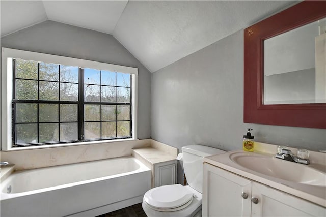 full bath with a garden tub, toilet, vanity, and lofted ceiling