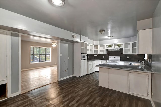 kitchen with visible vents, open shelves, a sink, white appliances, and a peninsula