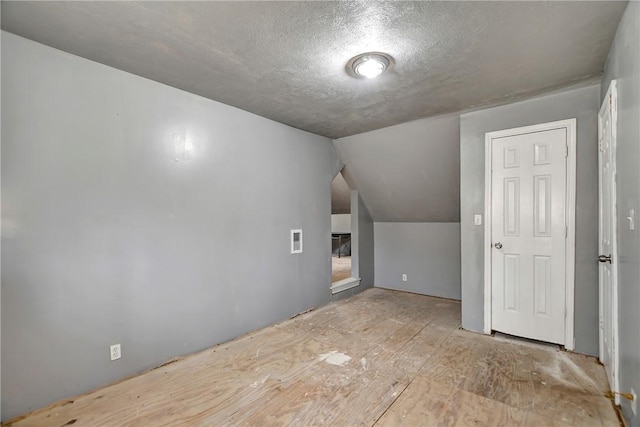 bonus room with visible vents, a textured ceiling, and vaulted ceiling