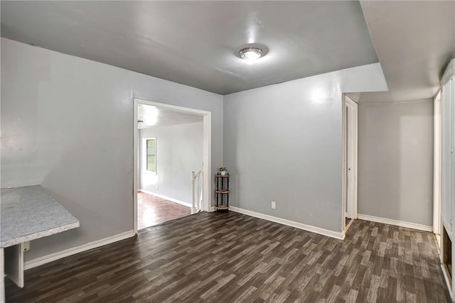 spare room featuring baseboards and wood finished floors