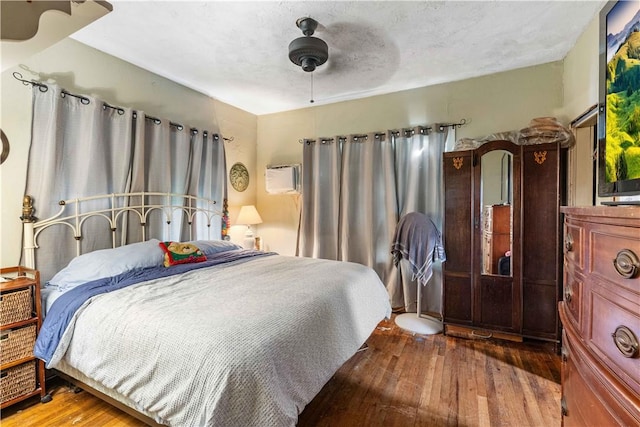 bedroom with hardwood / wood-style floors, a textured ceiling, and ceiling fan