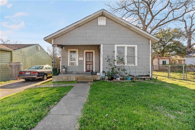 bungalow-style house with a front yard and covered porch