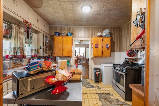 kitchen with stainless steel gas range and wooden walls