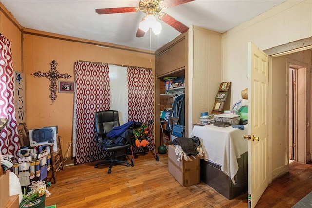 office space with crown molding, ceiling fan, and light wood-type flooring