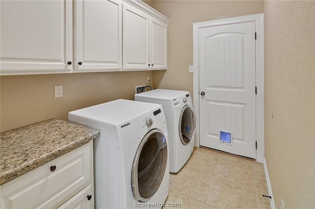 laundry area with cabinets, light tile patterned floors, and separate washer and dryer