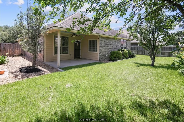 back of property with ceiling fan, a patio area, and a yard