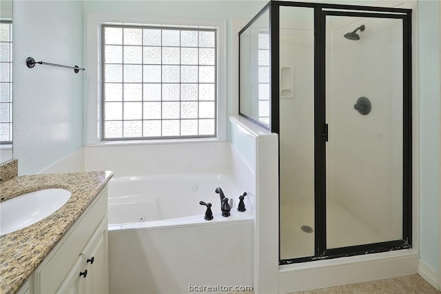 bathroom with vanity and shower with separate bathtub