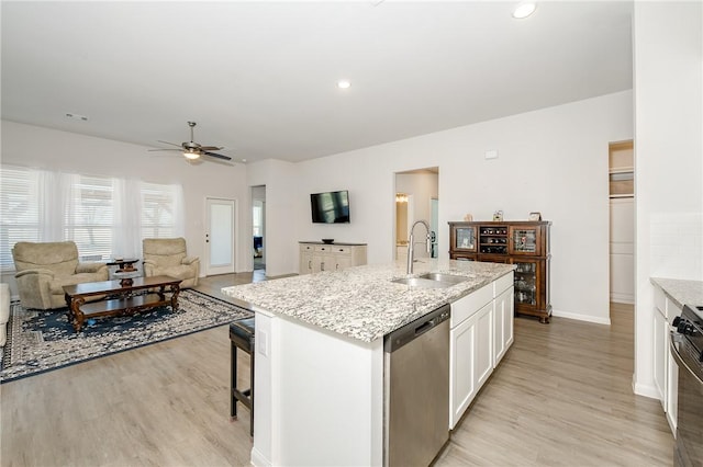 kitchen with sink, white cabinetry, light stone countertops, an island with sink, and stainless steel dishwasher