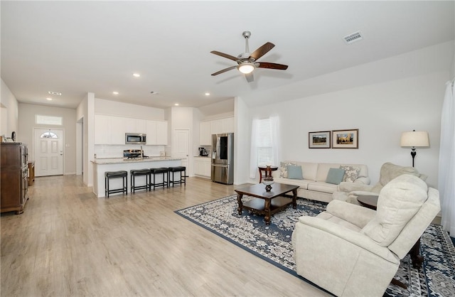 living room featuring ceiling fan and light wood-type flooring