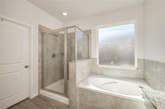 bathroom featuring hardwood / wood-style flooring, a healthy amount of sunlight, and plus walk in shower