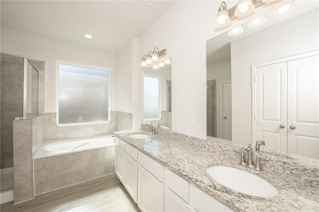 bathroom featuring vanity, wood-type flooring, and separate shower and tub