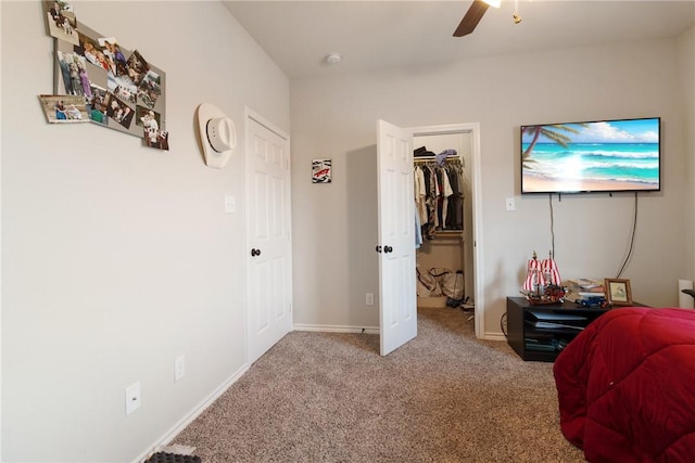 carpeted bedroom featuring ceiling fan, a closet, and a spacious closet