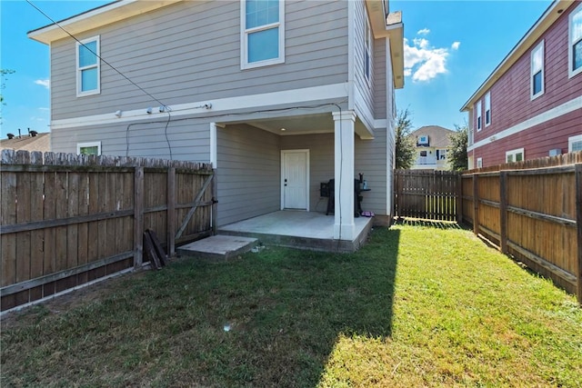 rear view of house featuring a patio area and a yard