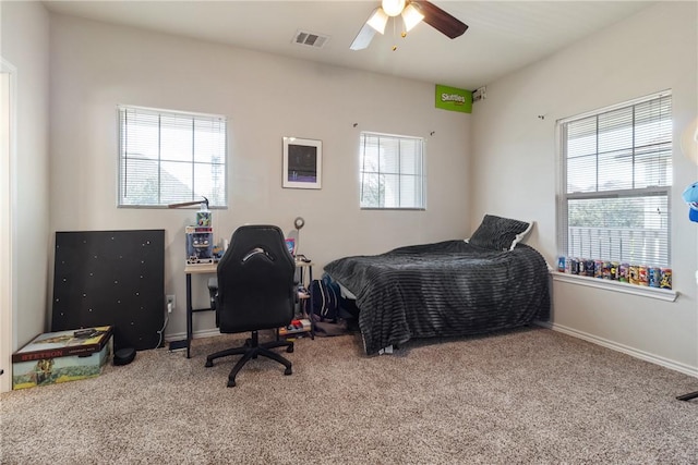 bedroom with multiple windows, ceiling fan, and carpet floors