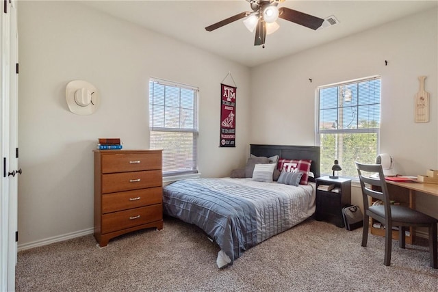 bedroom featuring ceiling fan, light colored carpet, and multiple windows