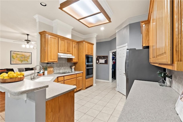 4906 Park Row Pl, Bryan, TX 77802 - kitchen featuring appliances with stainless steel finishes, under cabinet range hood, crown molding, a peninsula, and light countertops