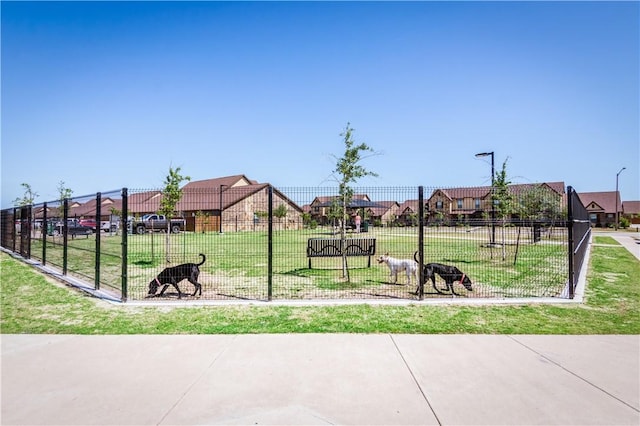 view of play area featuring a lawn, fence, and a residential view