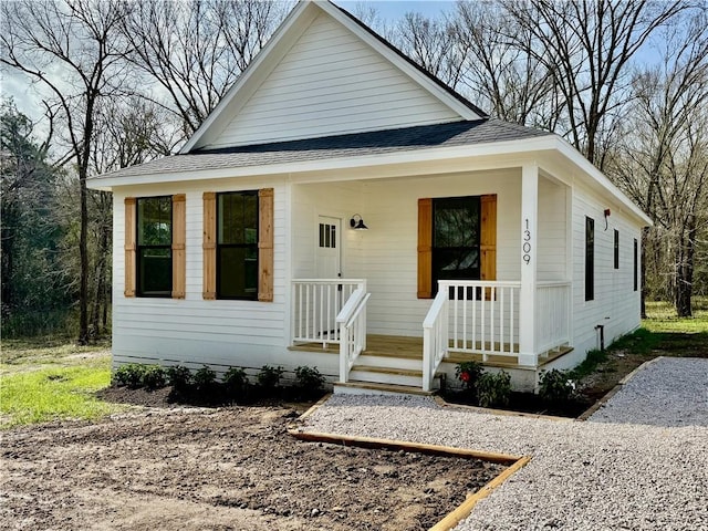 view of front facade with a porch and roof with shingles