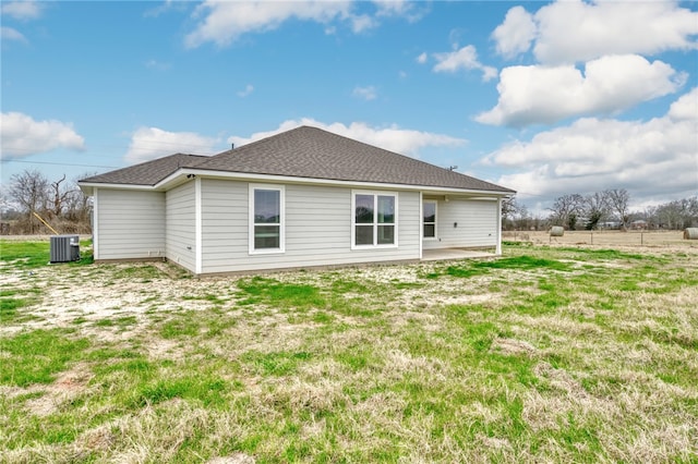 back of house with a shingled roof, a lawn, a patio area, and central air condition unit