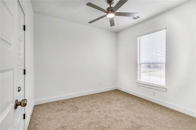 unfurnished room featuring a ceiling fan, light colored carpet, visible vents, and baseboards