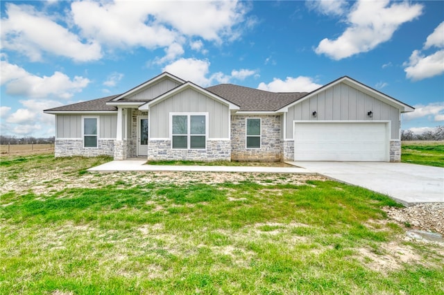 view of front of property with concrete driveway, stone siding, an attached garage, board and batten siding, and a front yard