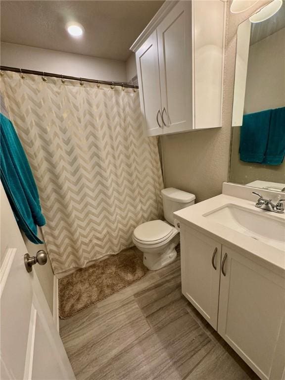 bathroom featuring hardwood / wood-style flooring, vanity, and toilet