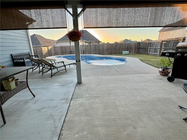 pool at dusk featuring a patio area