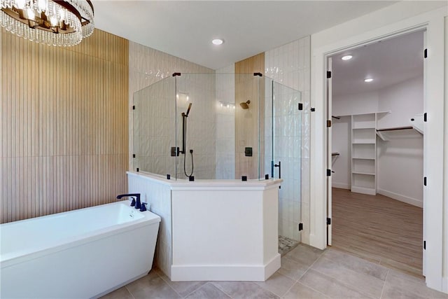 bathroom featuring tile patterned floors, a notable chandelier, and shower with separate bathtub