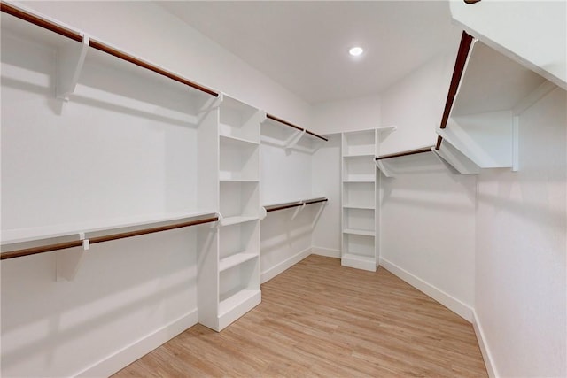 spacious closet with light hardwood / wood-style flooring