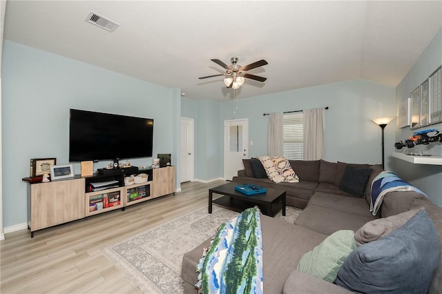 living room with visible vents, a ceiling fan, light wood-style floors, baseboards, and vaulted ceiling