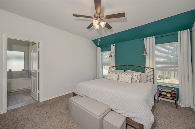 carpeted bedroom with ceiling fan, ensuite bath, and baseboards