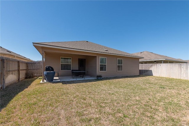 rear view of house with a patio area, a lawn, and a fenced backyard