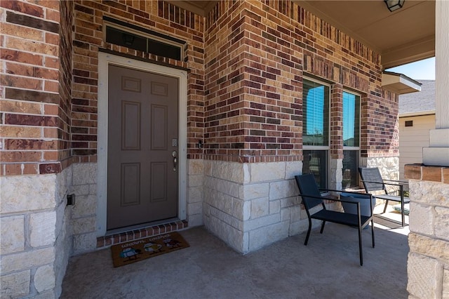 property entrance with brick siding and covered porch